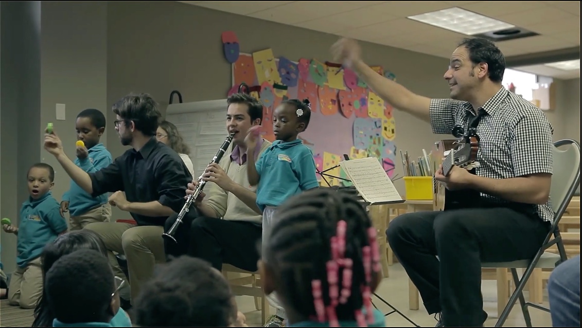 José performing music with young students in a classroom